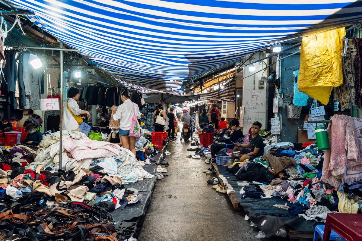 Người mua chọn quần áo đã qua sử dụng tại chợ Hoàng Hoa Thám, TP.HCM. Phong cách riêng bắt đầu từ cách chọn, phối và giữ lại một món đồ. Ảnh: Phạm Thục Khuê.